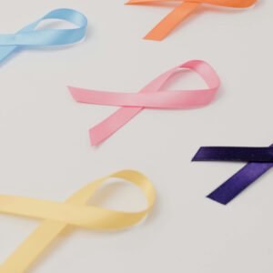 Pink, purple, and yellow cancer awareness ribbons for cancer insurance policy